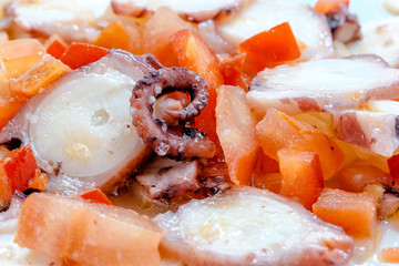 Octopus salad with tomatoes, red pepper, onion, olive oil, vinegar and salt