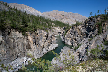 The narrow rocky canyon on a mountain river. River Omulevka. Magadan Region. Russia.