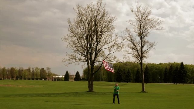 Man waving American flag on a glade
