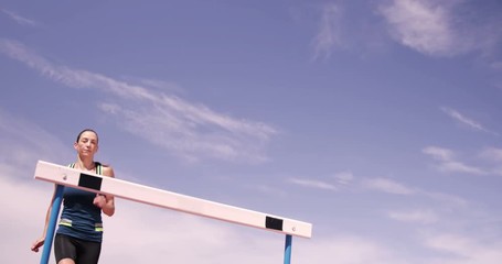 Sportswoman practicing hurdle race