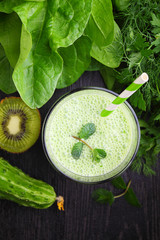 A glass of smoothie with green vegetables and spinach