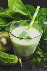 A glass of smoothie with green vegetables and spinach