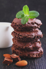 Chocolate meringue cookies with nuts on a black background