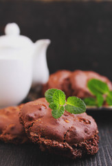 Chocolate meringue cookies with nuts on a black background