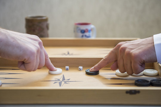 Two men play backgammon