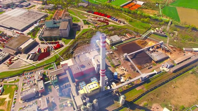 Modern combined heat and power plant from above. Fuming chimney with sulphur removal unit. Aerial view of heavy industry. Camera flight over industrial landscape in Czech Republic, European Union.