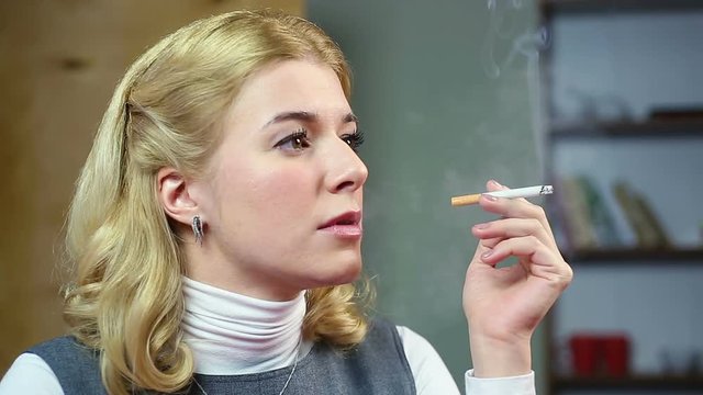 Female thinking about her life and smoking a cigarette. Unhealthy lifestyle