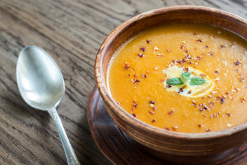 Bowl of spicy pumpkin cream soup on the wooden table