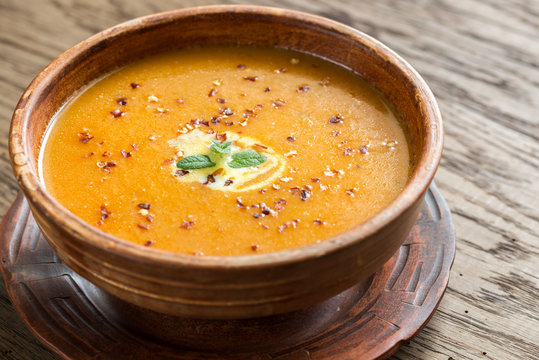 Bowl of spicy pumpkin cream soup on the wooden table