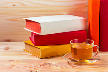 Cup of tea and books onwooden background