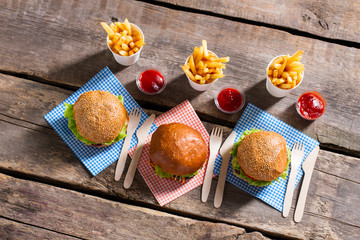 Burgers with cutlery and fries. Hamburgers and cutlery on table. Freshly cooked meal at bistro. Dinner in fast food cafe.