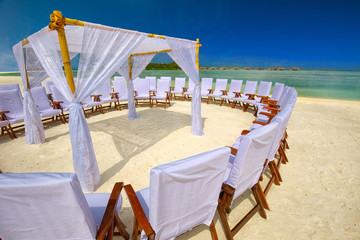 Decorated chairs and arch for wedding ceremony on tropical island in Maldives