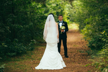 Newly married couple dancing in field. Outdoor portrait of bride and groom