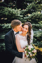 Naklejka premium Elegant bride and groom posing together outdoors on a wedding day