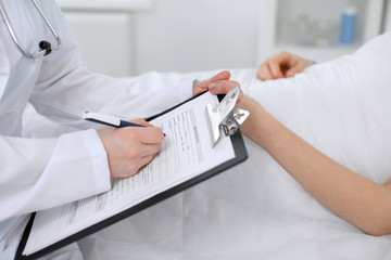Close-up of a female doctor holding application form while consulting patient