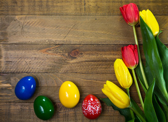 Tulips and Easter eggs on a wooden table