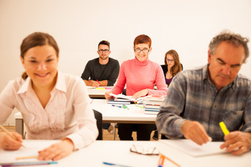Group of people of different age sitting in classroom and attend