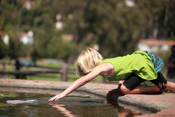 A girl playing around a pool. 