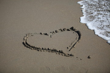 Shape of a heart on the beach, soft wave of the sea.
