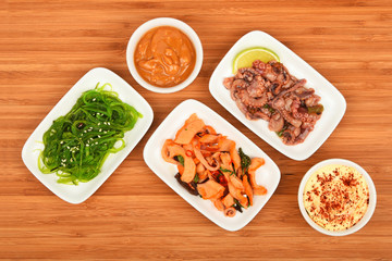 Three seafood salads with sauce on wood
