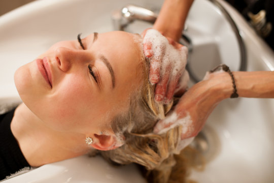 Hair Stylist At Work - Hairdresser Washing Hair To The Customer