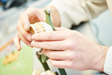 hands of dental technician working with tooth dentures