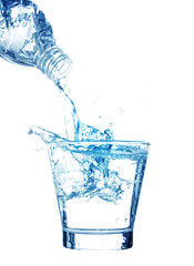 Pouring water on a glass on white background