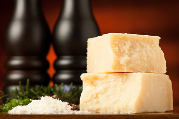 pieces of parmesan cheese on a wooden cutting board being cutted