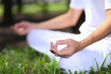Attractive young man doing yoga. Focus on hand of maditation.