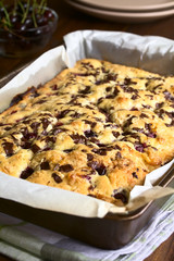 Cherry blondie or blond brownie cake baked with white and dark chocolate, photographed in baking pan with natural light (Selective Focus, Focus one third into the cake)