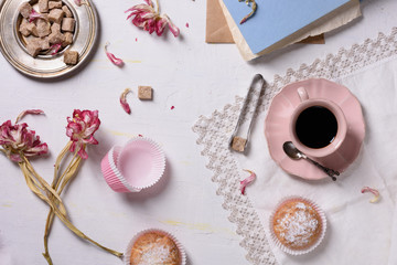 Romantic breakfast, fresh coffee, cupcake desserts and pink flowers served with love. Top view. 