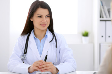 Brunette female doctor talking to patient in the hospital