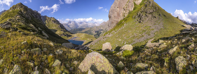 Panorama of a mountain valley with hills and lake in the summer sunny day in Abkhazia