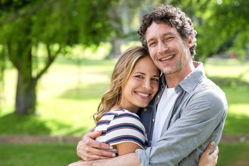 Smiling couple embracing in park
