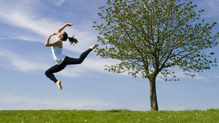 Young dancer jumps in the air outside