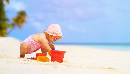 cute little girl play with sand on the beach