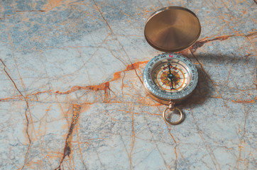 Fototapeta na wymiar Compass on marble stone background