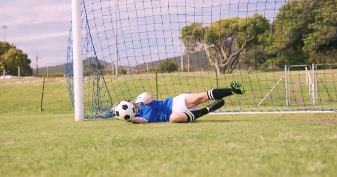 Goalkeeper in blue making a save
