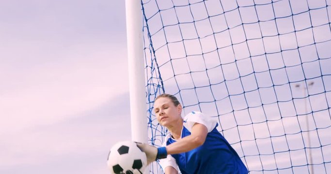 Goalkeeper in blue making a save