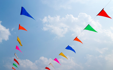 Multi Colored Triangular Flags Hanging in the Sky at an Outdoor