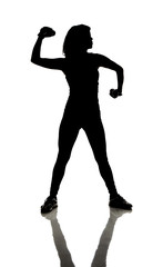 Silhouette of athletically fit woman doing curls with dumbbells.