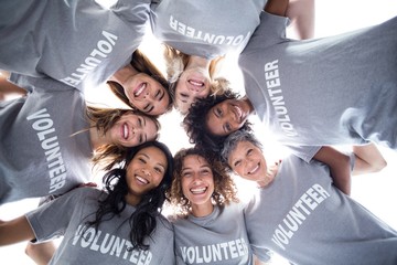 Happy multi-ethnic volunteers forming a huddle