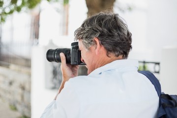 Rear view of man using camera