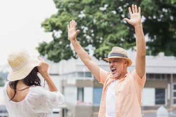 Obraz premium Woman photographing man with arms raised