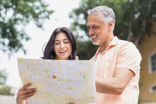 Cheerful couple reading map