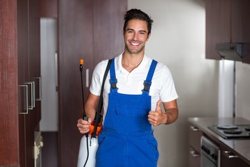 Man doing pest control in kitchen