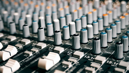 Mixing Board Sound Knobs. Pro audio mixing board faders and knobs, multi-track music recording equipment.