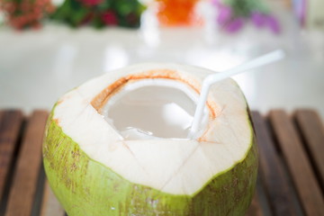 Young coconut with flower on wooden table