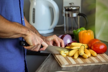 Man chopping vegetables at kitchen counter