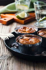 Steak and mushroom pot pies in  aluminum foil dishes on picnic table